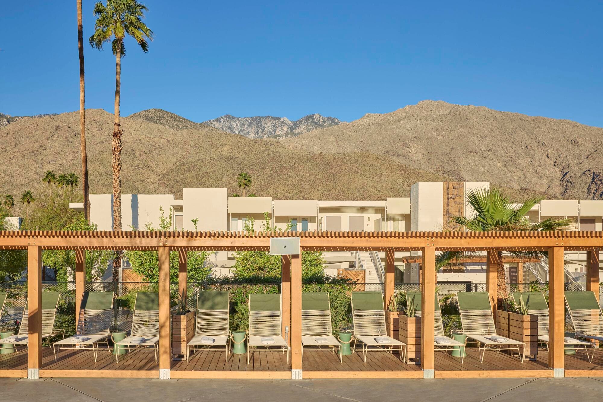 Timber pergola over the Ace Hotel pool deck, the stucco room blocks and the San Jacinto mountains behind