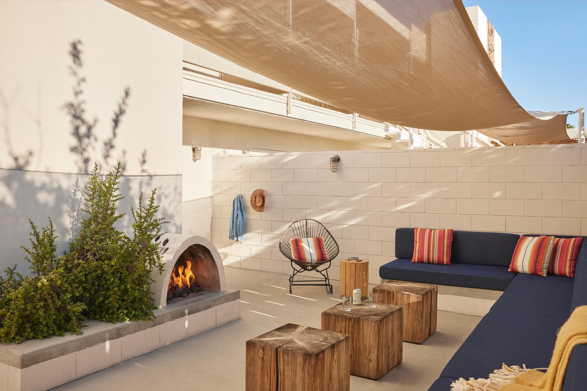 Sculpted plaster fireplace and split-face concrete block wall on a shaded Ace Hotel guest patio