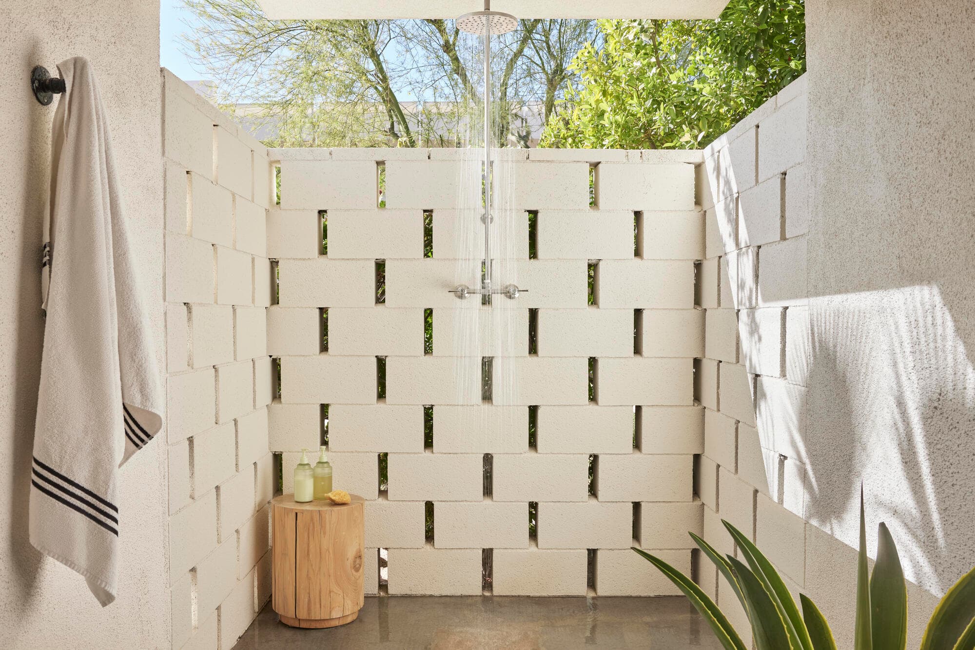 Private outdoor shower enclosed by an offset concrete breeze-block screen wall