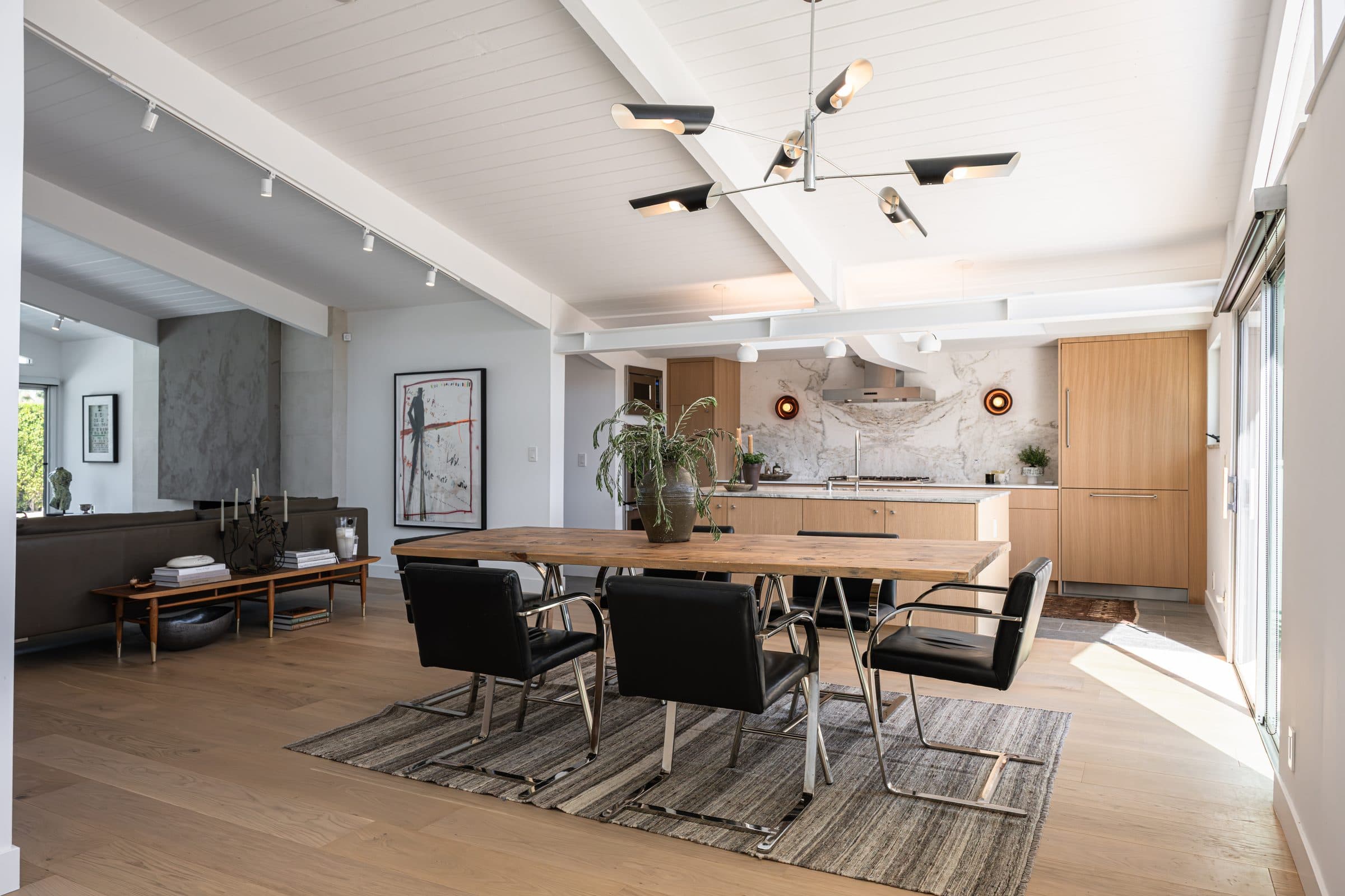 Dining, living, and kitchen in a single sweep under the exposed beams.
