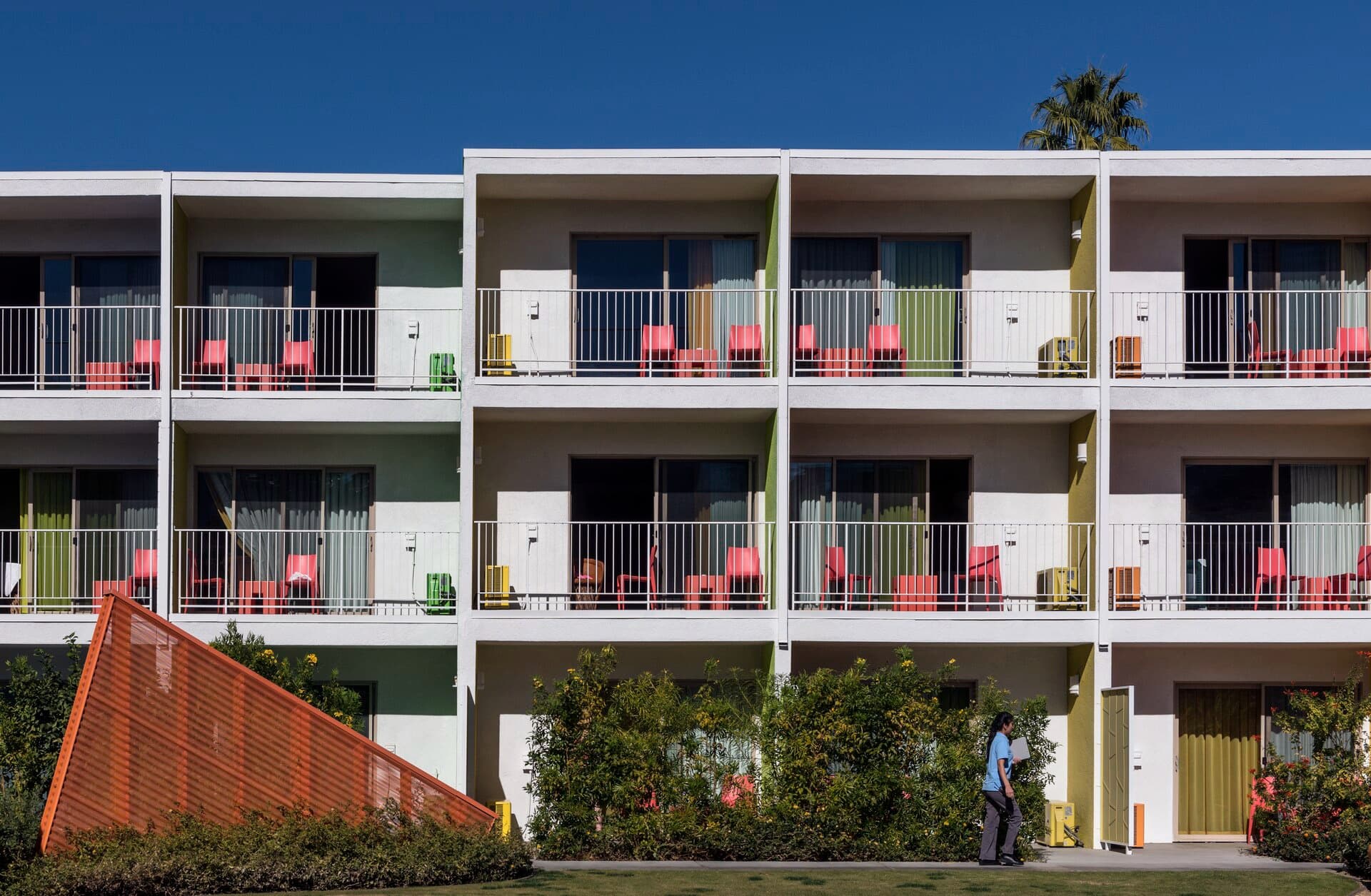 Green and white balconies with coral chairs